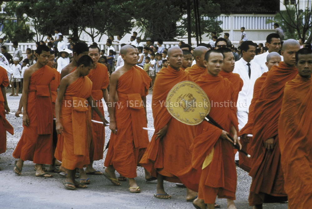 DP28_16 - A view of a procession of Buddhist monks with one holding a large Buddhist fan.